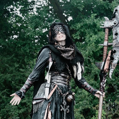 Femme en tenue déchirée avec une grande hanche et un masque sur un fond de feuilles