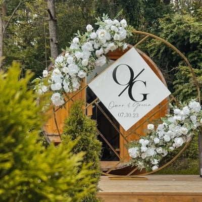 wedding ceremony gold chrome circle backdrop with white floral arrangements