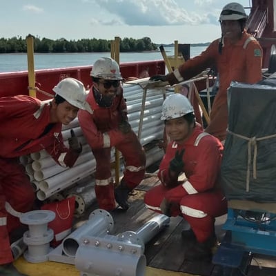 a group of people in red suits and white helmets on a boat