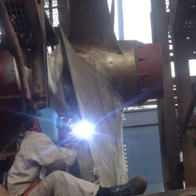 a man welding a piece of metal with a welding torch