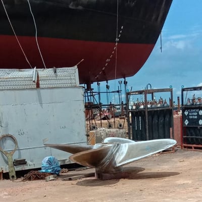 a boat sitting on the ground next to a large boat