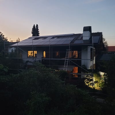 a house with a solar paneled roof and a ladder