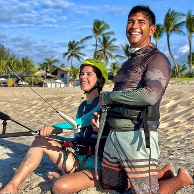 mulher jovem fazendo aula de kitesurf ao lado do instrutor.