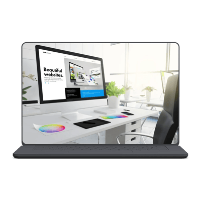 Modern workstation with iMac showing web design, colorful swatches, and plants in a bright office setting.