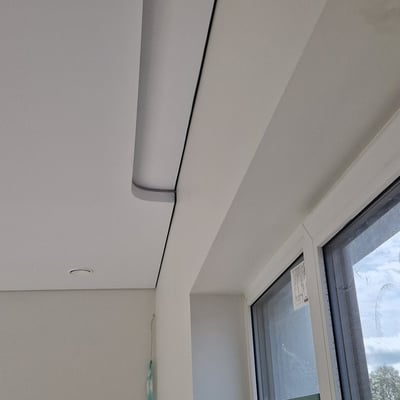 a ceiling with a ceiling fan and a window