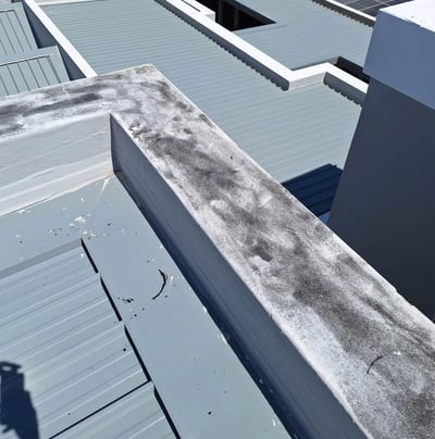 Roof flashing lifted near parapet wall