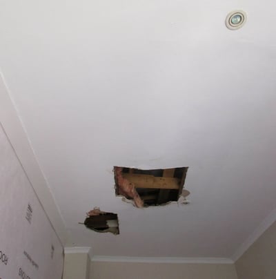 Hole in ceiling showing roof board failure