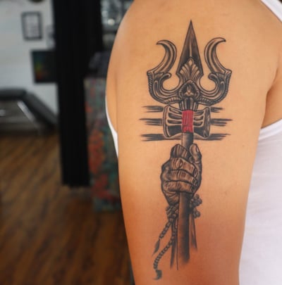 Unique Trishul and damru tattoo design by Dudo’s Tattoos and Piercing in Hyderabad