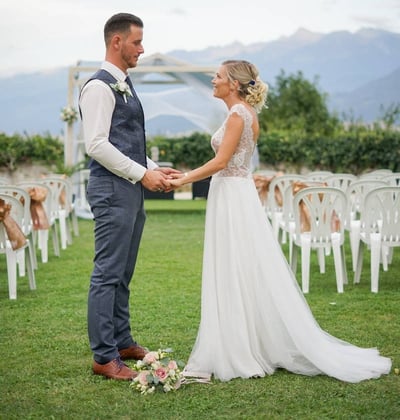 Photo d'un couple de mariés face à face se tenant la main sur le lieux de leur cérémonie de mariage