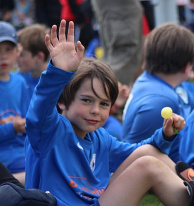 enfant de face levant la main