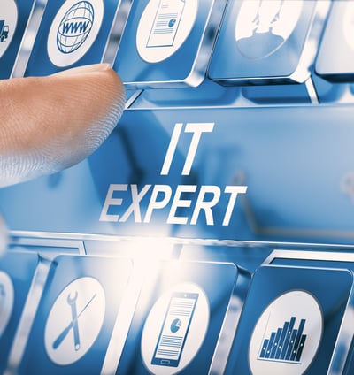 Finger pressing "IT expert" key on a keyboard with icons representing IT services and infrastructure