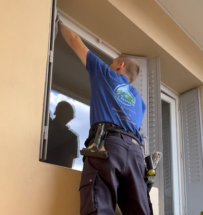 Une personne qui nettoie les encadrements d'une vitre
