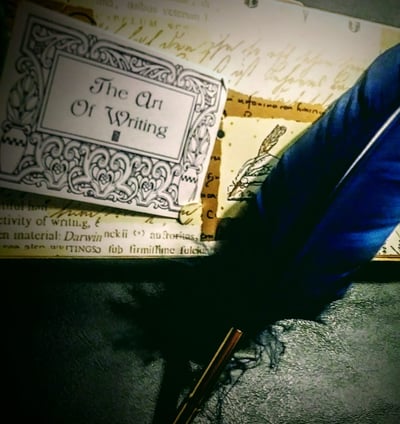A blue feathered quill on a dark background - The Art Of Writing