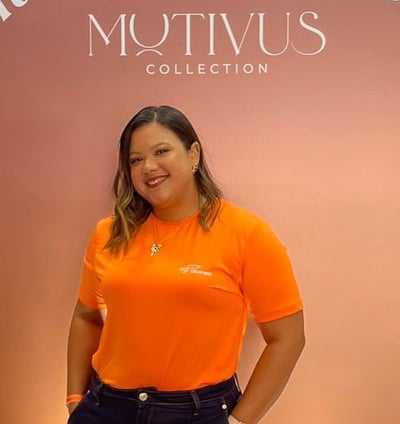 a woman in a bright orange shirt and jeans