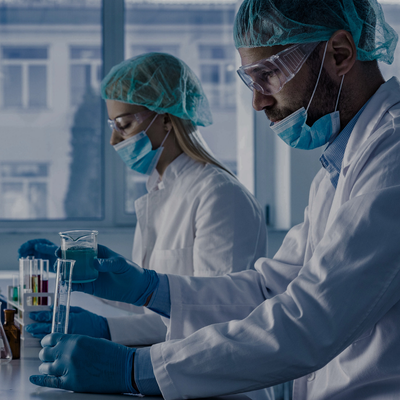 two people in lab coats and masks on a lab