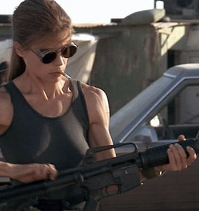 a woman in a tank top holding a gun