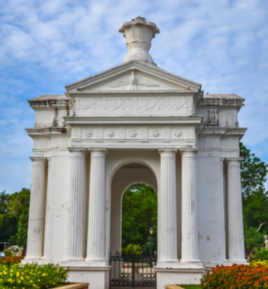 A structure with white paint and greenery around