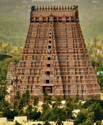 A huge Temple  gopura with green backdrop depicting the Hindu temple