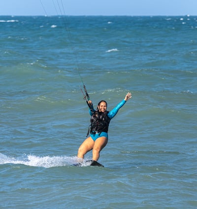 mulher velejando de kitesurf no mar.