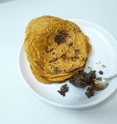 alt="Besan Chilla served with homemade pickle on a white plate"