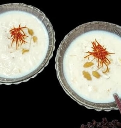 alt="Bread Kheer served in glass bowls topped with almonds, raisins, and saffron strands"