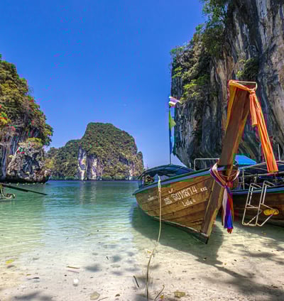 Krisa Travel Agent Krabi Tour boats in the water near a cliff