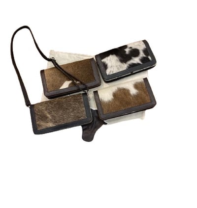 a pair of two leather wallets with a cowhide hideaway pouch