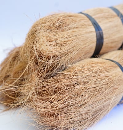 a couple of brooms sitting on top of a pile of hay