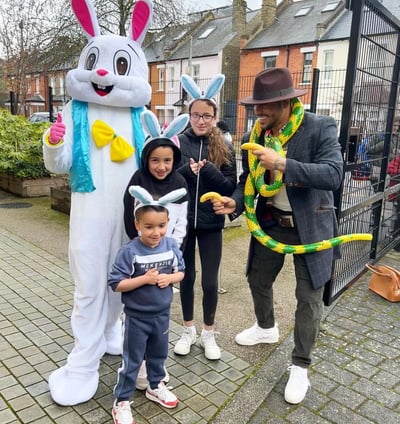 a person in a bunny suit and children wearing a bunny ears