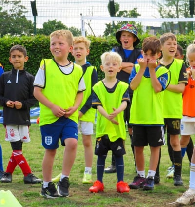 a group of young children football players standing in a field