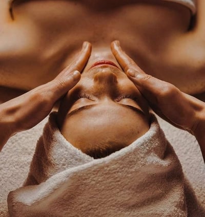 a woman getting a facial massage at a spa