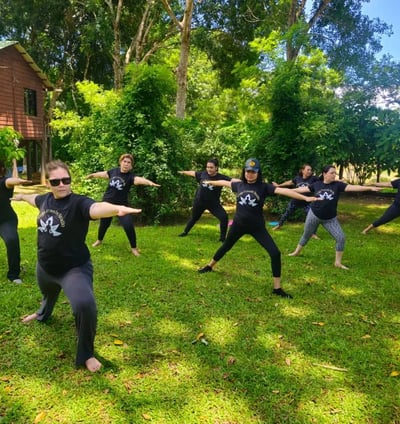a group of people doing yoga poses in a field