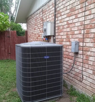 a large air conditioner sitting on the side of a brick building