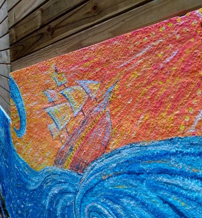 détail d'une peinture murale représentant un navire soumis à des vagues turbulentes