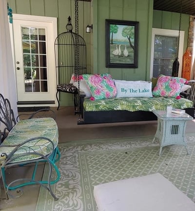 a covered terrace with a daybed and chairs