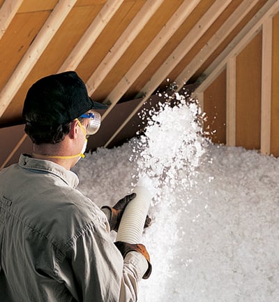 a man in a hat and gloves is holding insulation