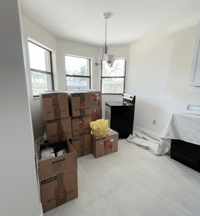 Packed moving boxes stacked in a bright kitchen space, ready for unpacking and setup.