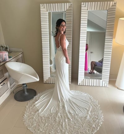 a woman in a wedding dress standing in front of a mirror