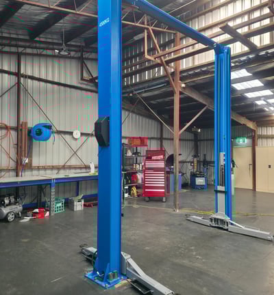 a workshop with a large hoist in the middle of a large warehouse
