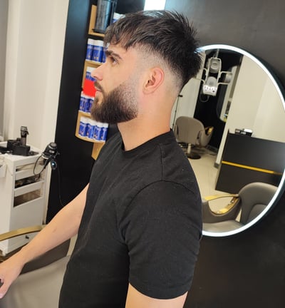a man in a black shirt is standing in front of a mirror
