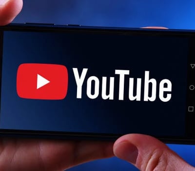 a person holding a phone with the youtube youtube logo on it