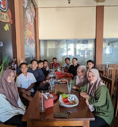 a group of people sitting at a table with food