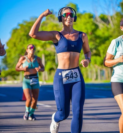 a woman running in a race with a headphones on