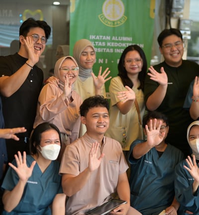 a group of people standing around a table with masks on
