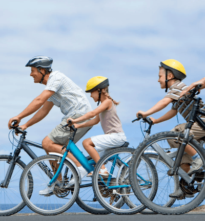 A family of three cycling in the outdoors.
