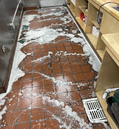 a restaurant tile kitchen floor with soap on it