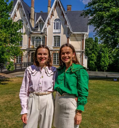 Deux personnes qui posent devant un chateau en souriant