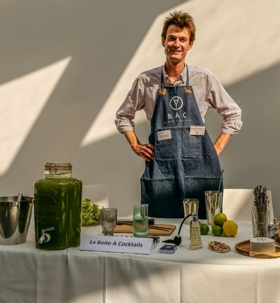 Personne qui pose derrière son stand qui propose des cocktails