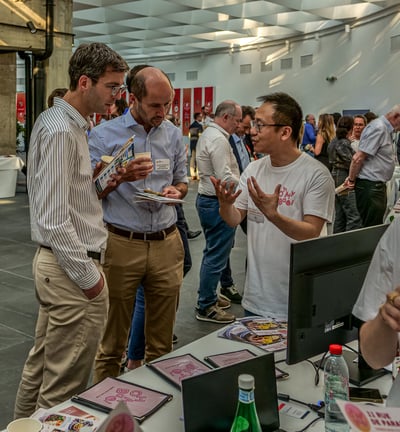 Trois hommes devant un stand qui discutent d'une entreprise qui frabrique des Baos