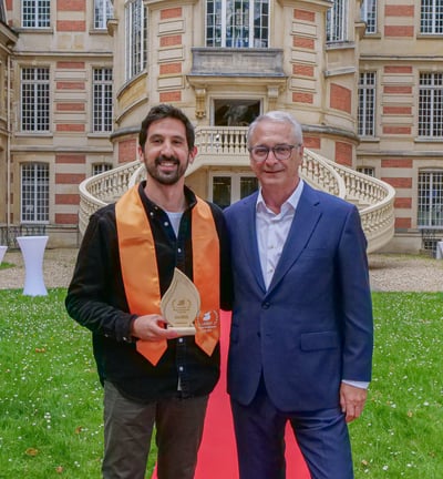 Deux hommes qui posent avec un trophée devant la mairie de Versailles